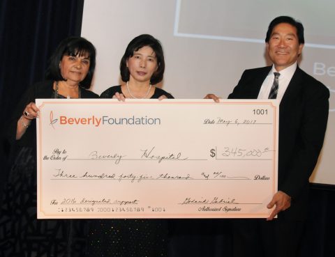 Go Gabriel, Alice Cheng, and Lester Fujimoto smile while holding up a large check for "$345,000.00" at the 2017 Paradise Ball
