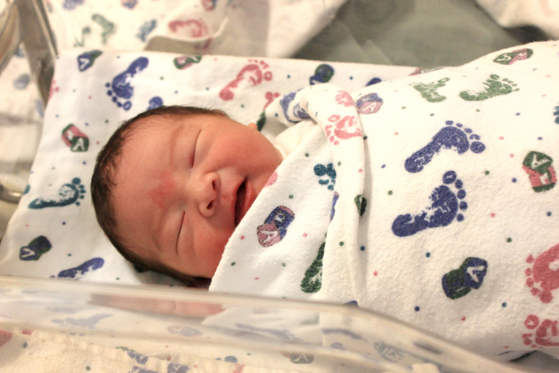 Close up photo of smiling newborn asian baby