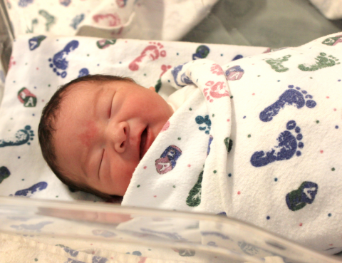 Close up photo of smiling newborn asian baby