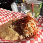 A pupusa with some pickled vegetables on top