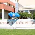 Outside photo of Beverly Hospital sign with blue and white balloons and baseball featuring the Dodgers logo print balloons