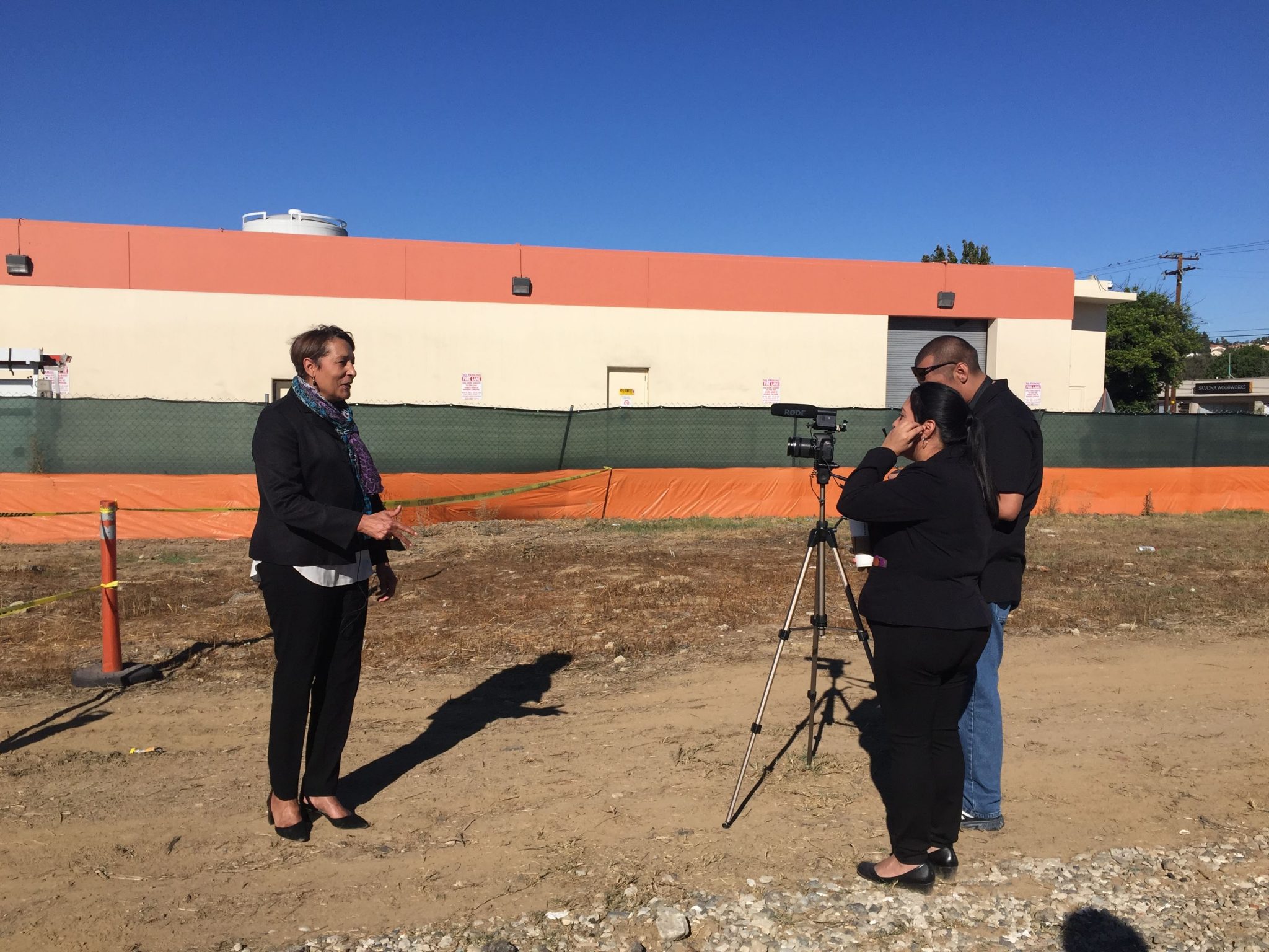 The chief nursing office (female) is being interviewed by two people outside at the Emergency Care Center expansion construction site
