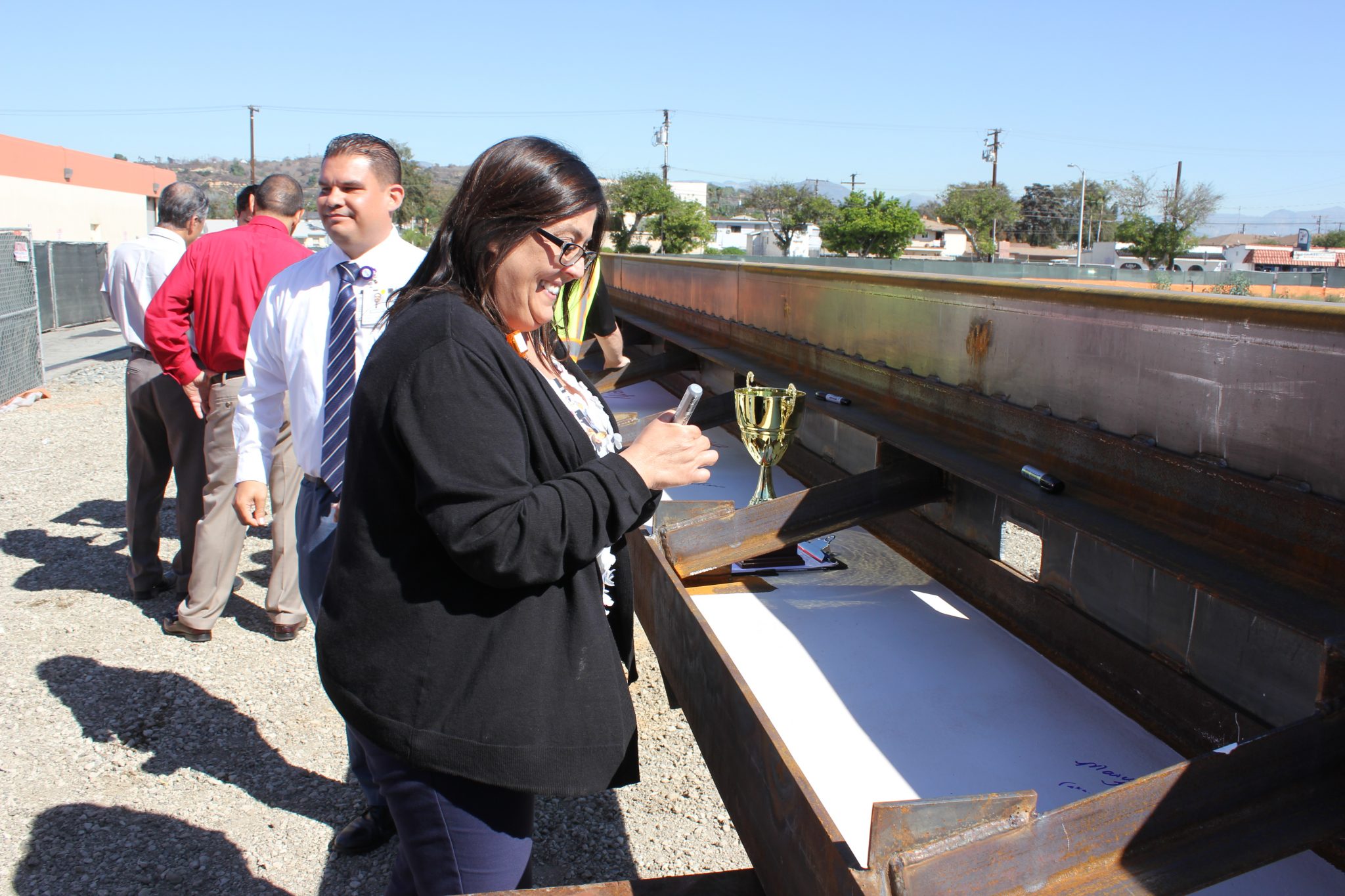 Marisela Torres smiles before she signs the final beam for the Emergency Care Center expansion.