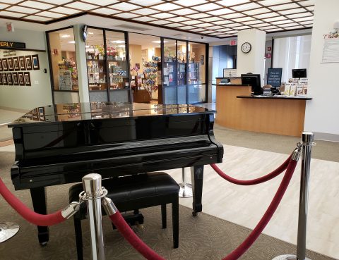 Black grand baby piano in Beverly Hospital's main lobby