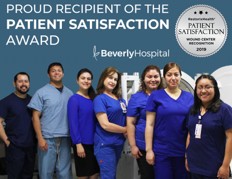 Graphic congratulating Wound Care Center team for 2019 Restorix Patient Satisfaction Award. Wound Care Center team standing next to Hyperbaric oxygen chamber