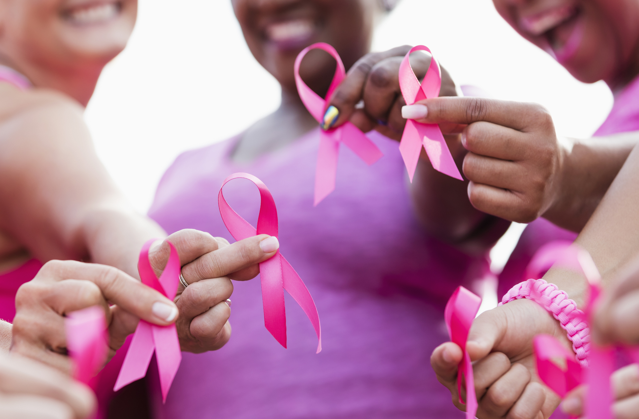 Close up of group of women holding pink breast cancer awareness ribbons