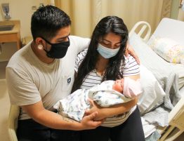 First time parents Pomona and Frank Ramos hold and look at their baby